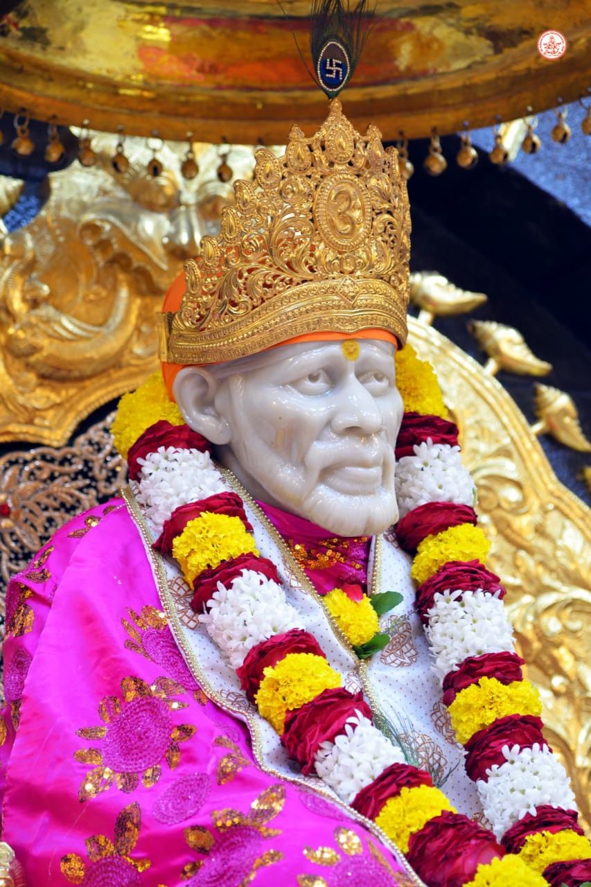 Sai Baba adorned with flowers, serene portrait