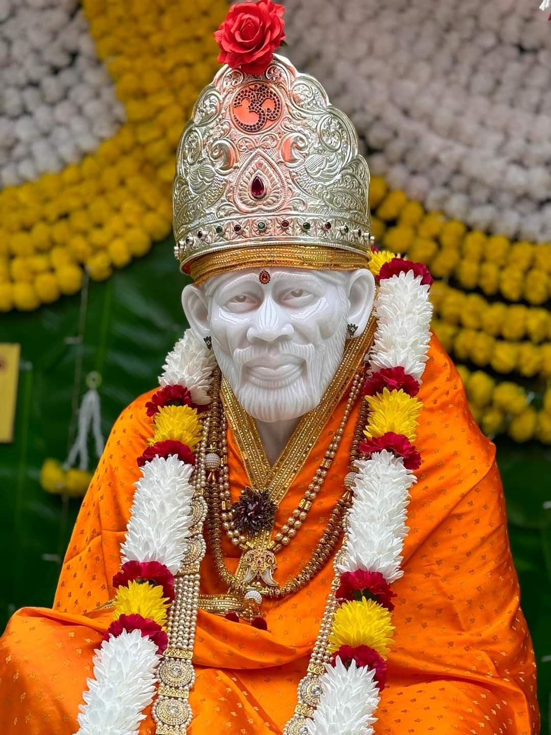 Sai Baba with flower garlands.