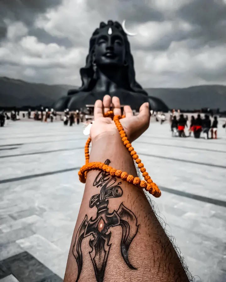 Mahadev statue and devotee’s hand.