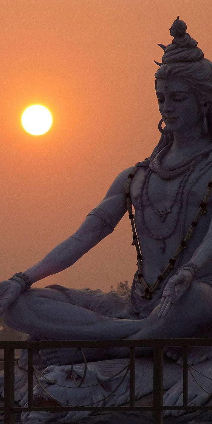 Shiva meditating at sunset statue