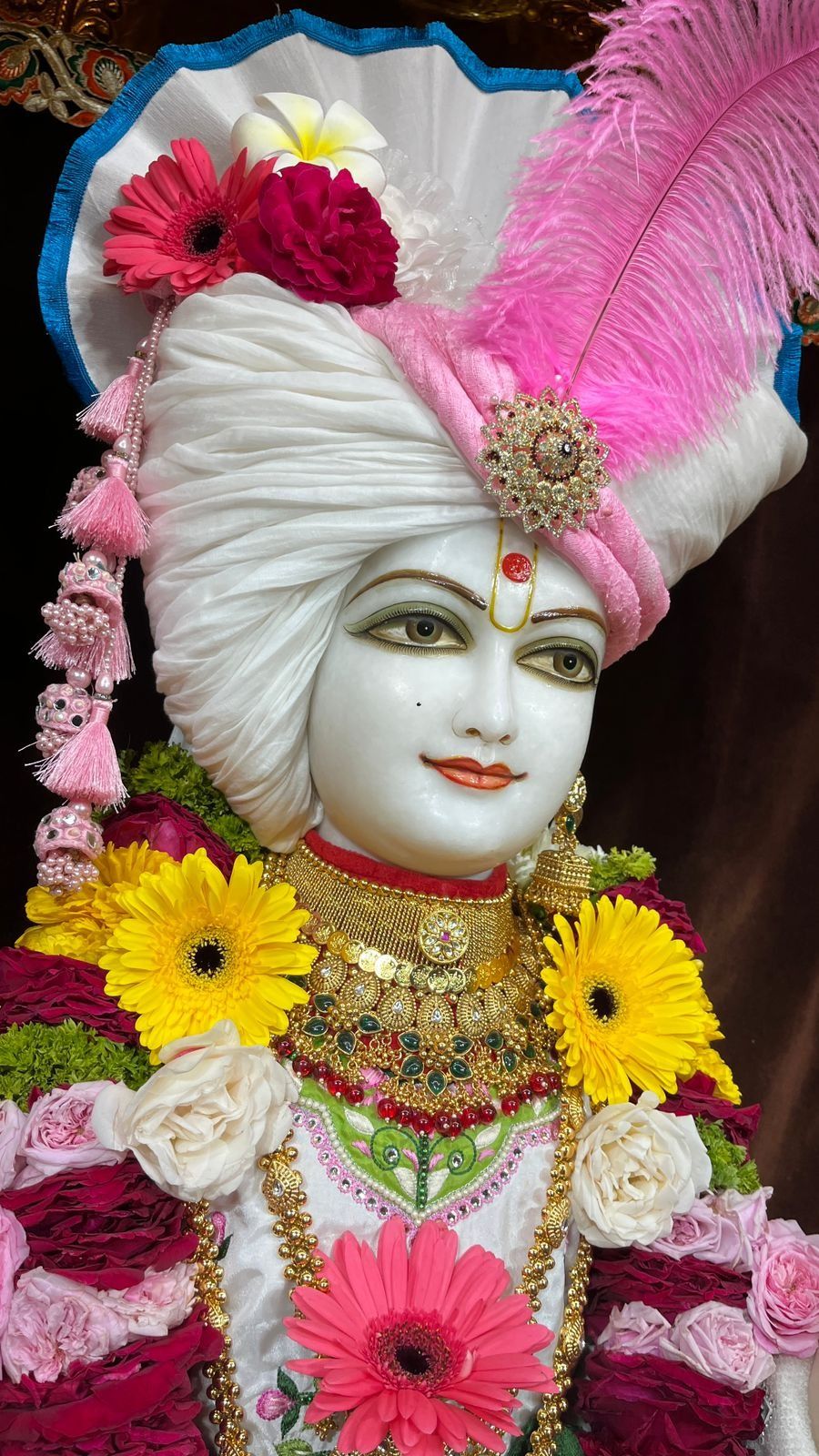 Swaminarayan adorned with colorful flowers.