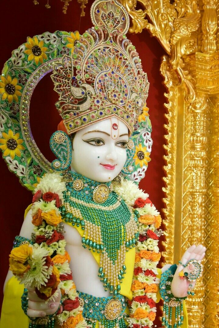 Swaminarayan deity adorned with flowers.
