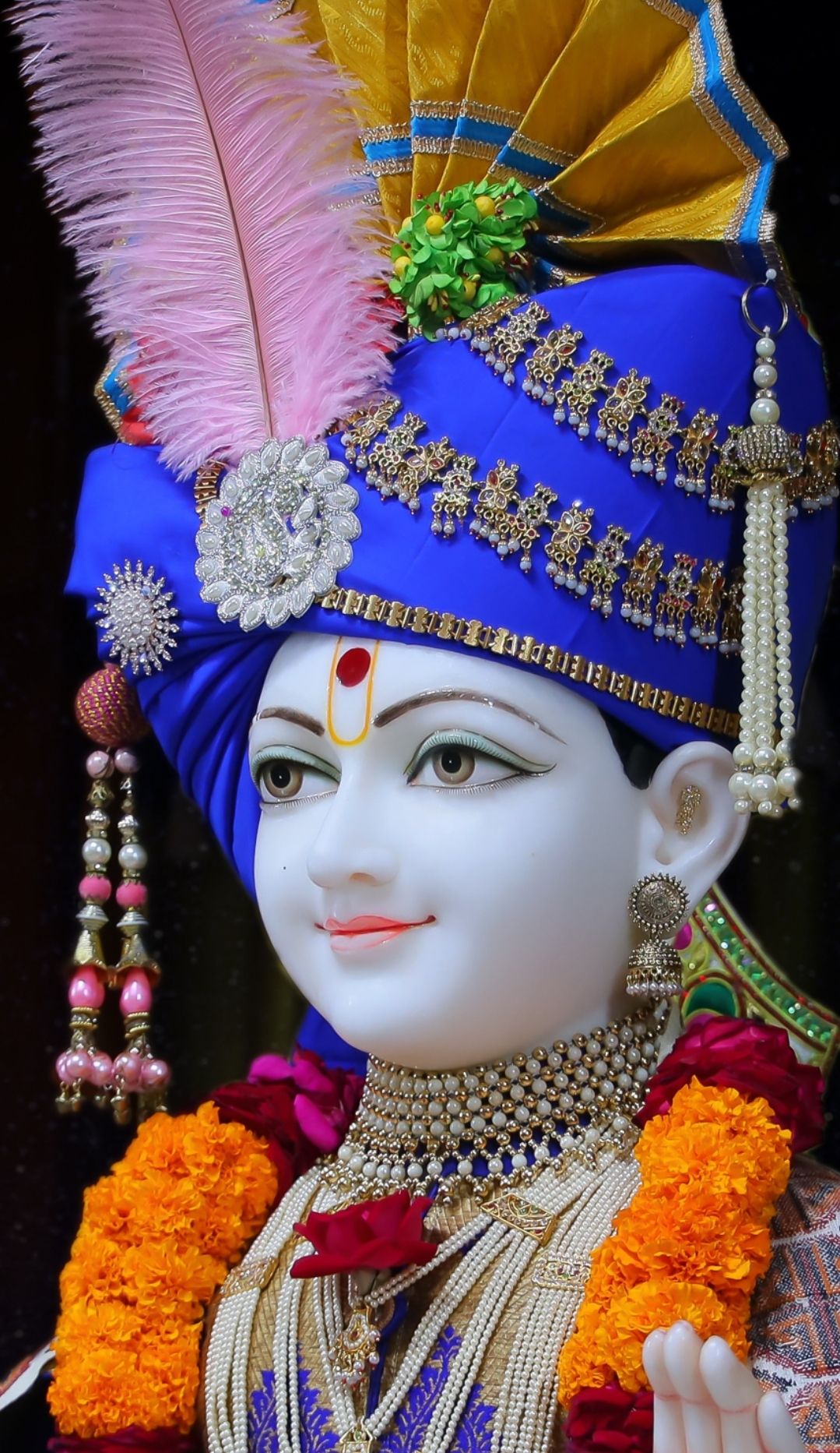 Swaminarayan with ornate headwear and garlands