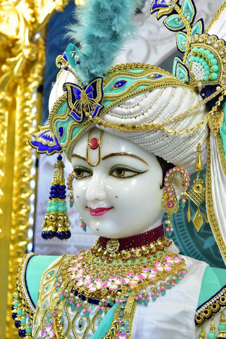 Swaminarayan with ornate golden crown.