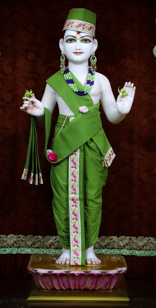 Swaminarayan statue in green attire.