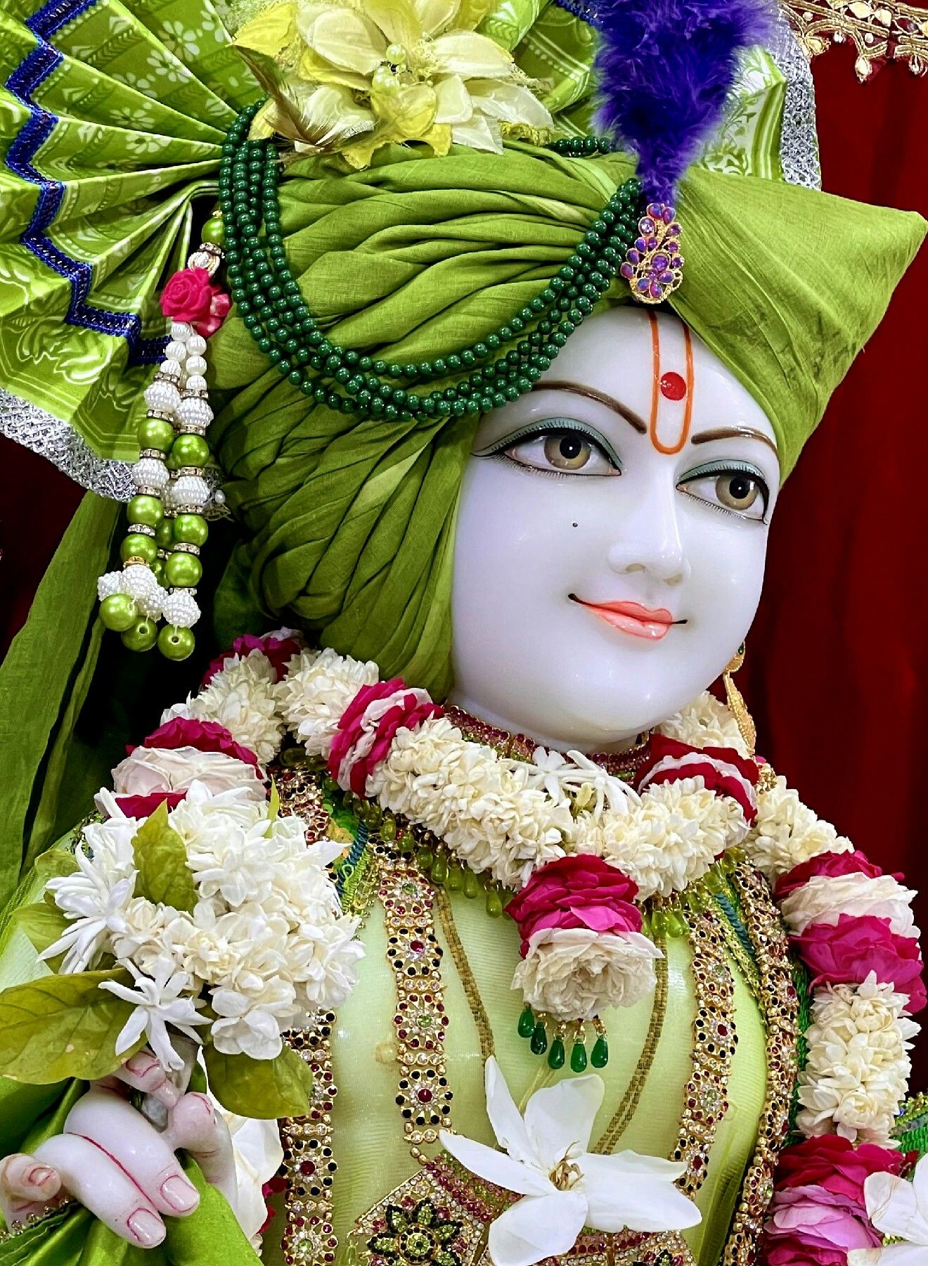 Swaminarayan with floral decorations, serene face