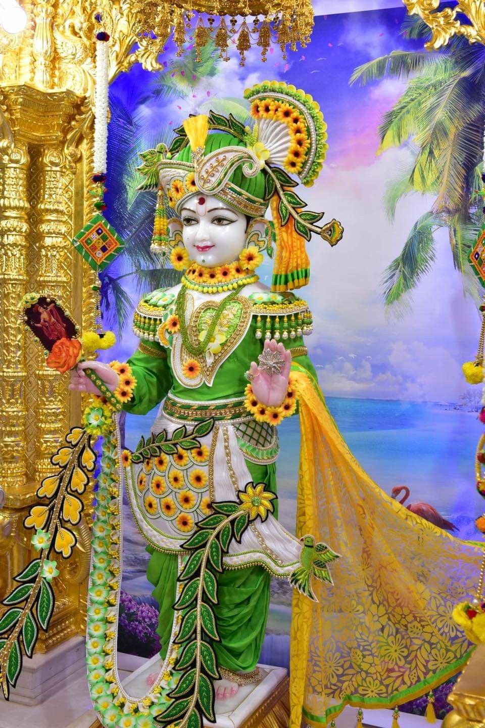 Swaminarayan in vibrant green attire.