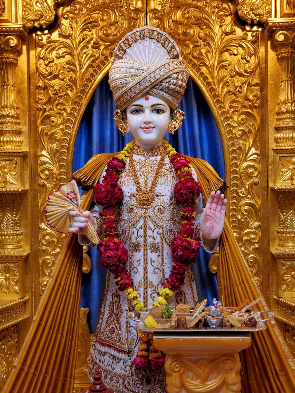 Swaminarayan statue with floral garland.
