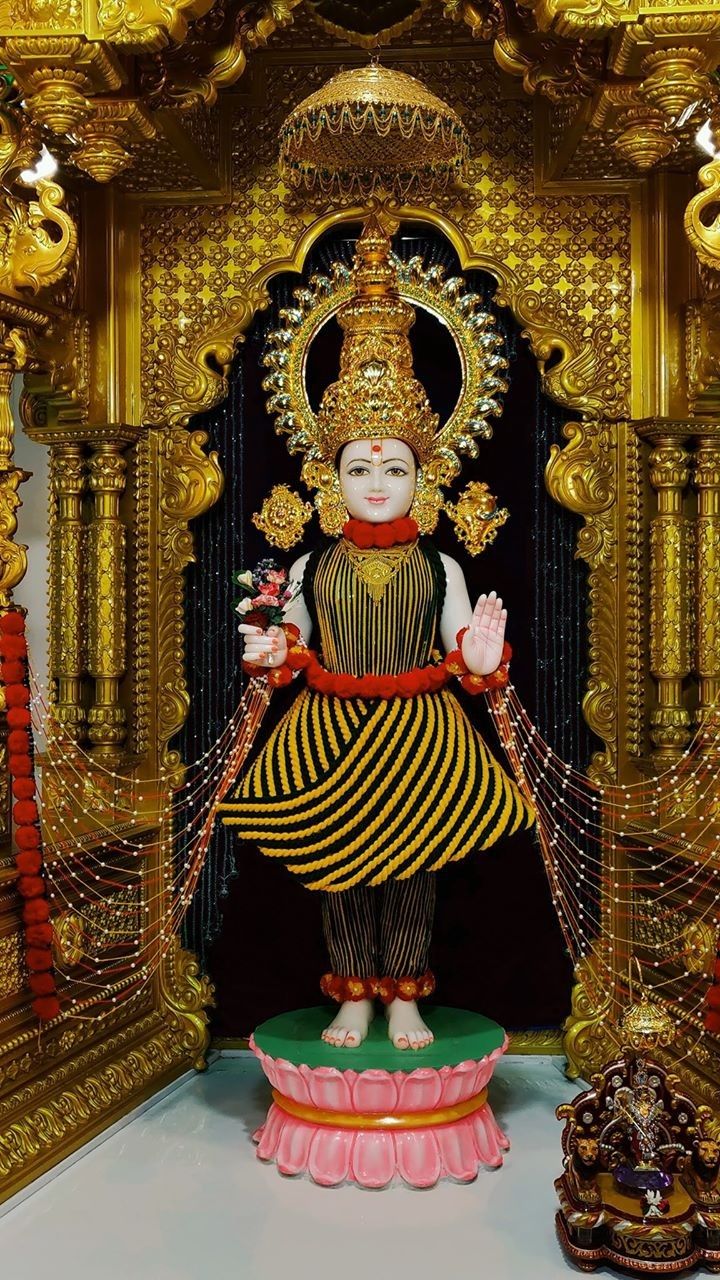 Swaminarayan murti in golden temple setting.