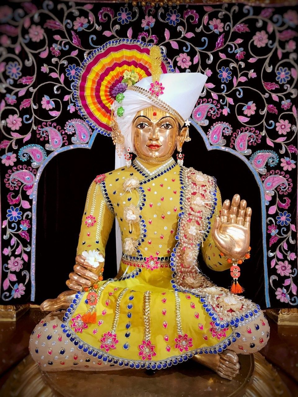 Swaminarayan idol in floral backdrop