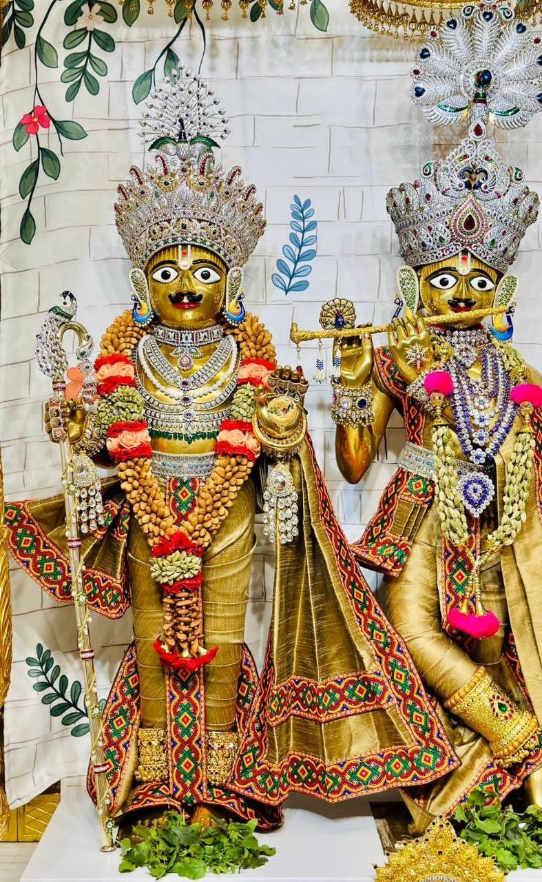 Golden Swaminarayan statue with floral decorations.