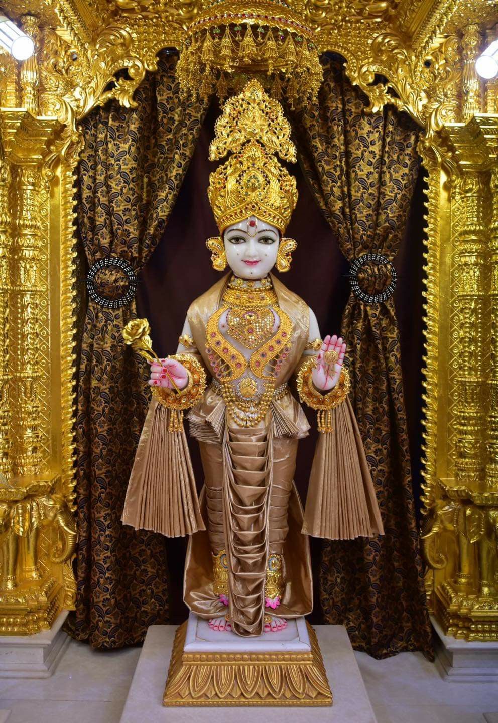 Golden Swaminarayan idol in temple setting