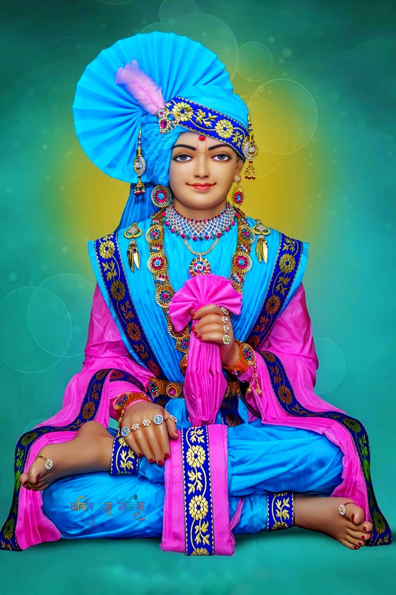 Swaminarayan in vibrant pink and blue attire.