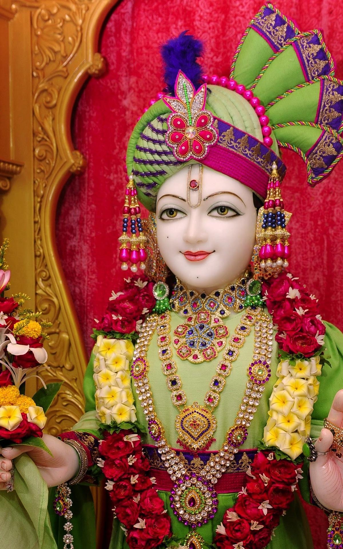 Serene Swaminarayan deity in floral attire.