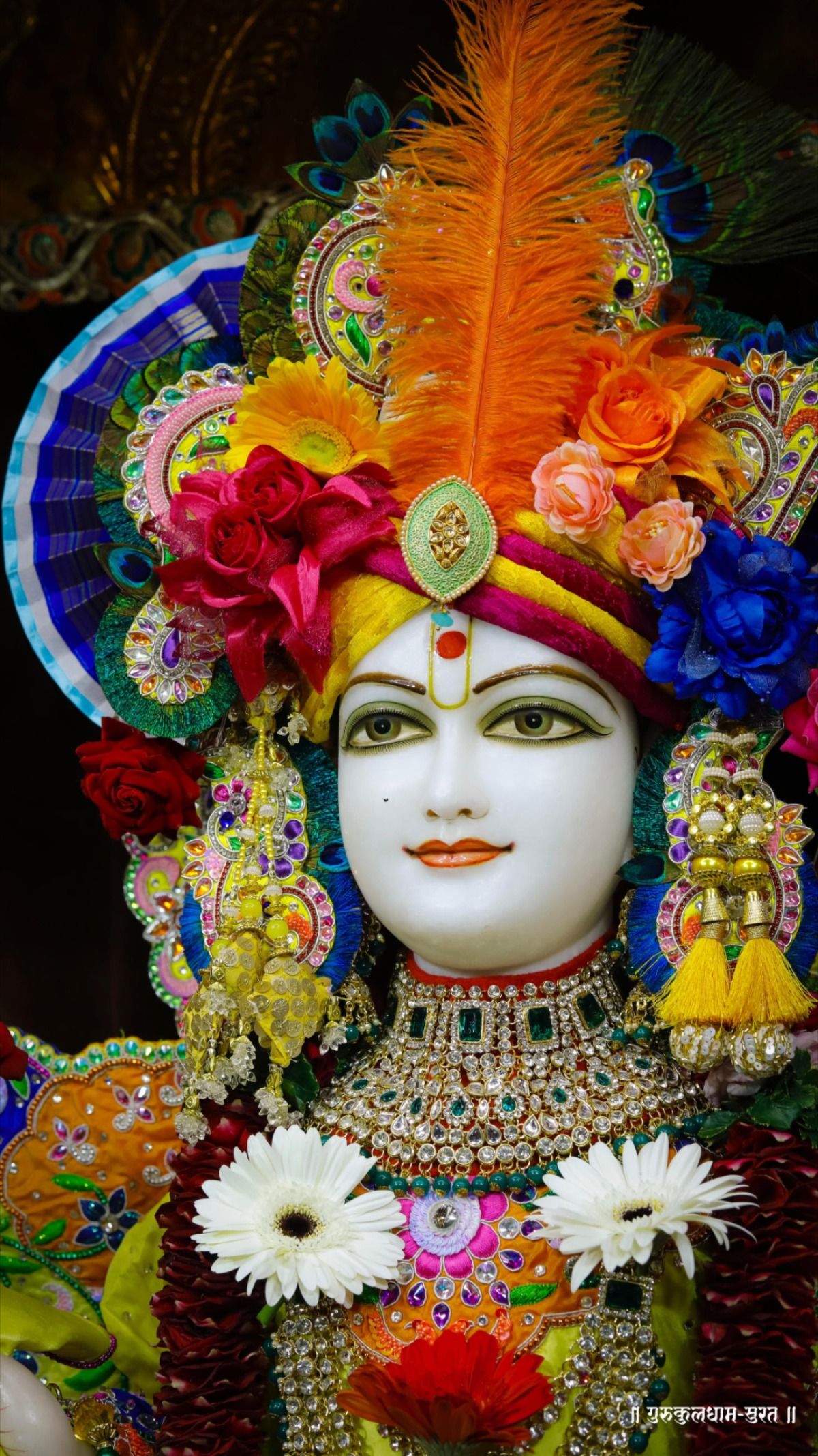 Swaminarayan adorned with flowers and feathers