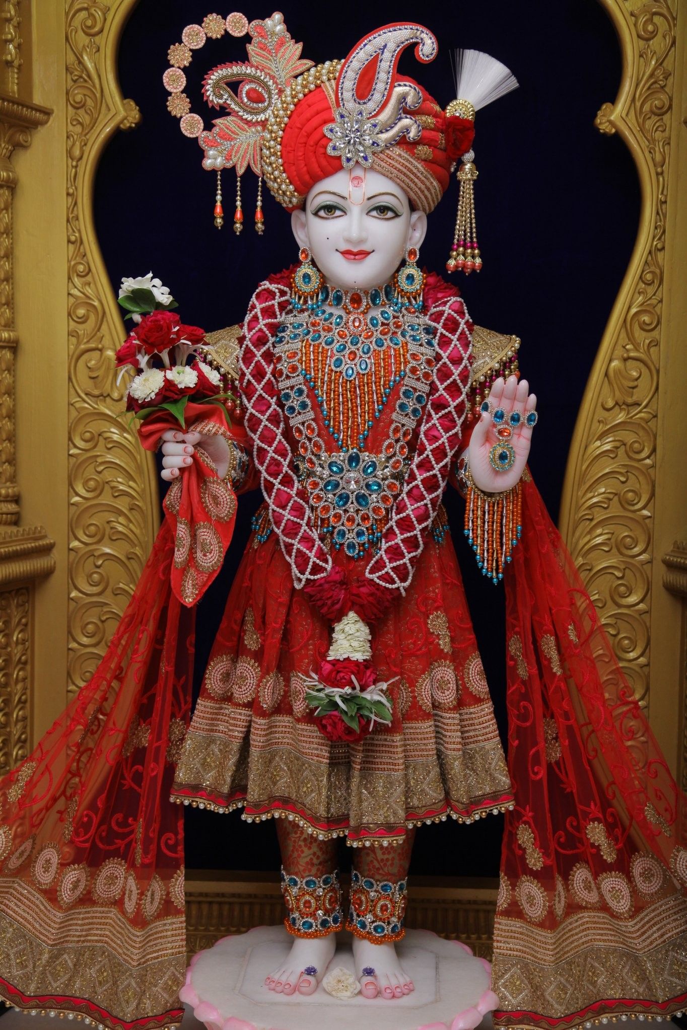Swaminarayan statue in red and gold.