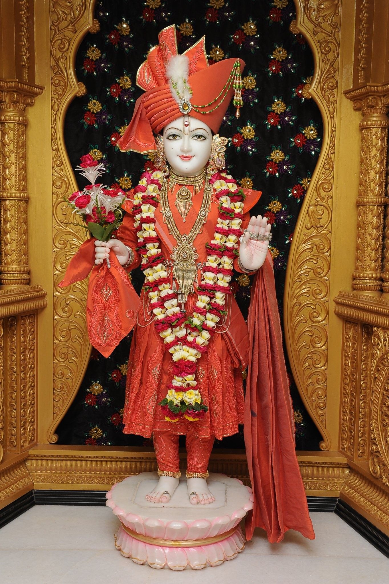 Swaminarayan murti in vibrant orange attire