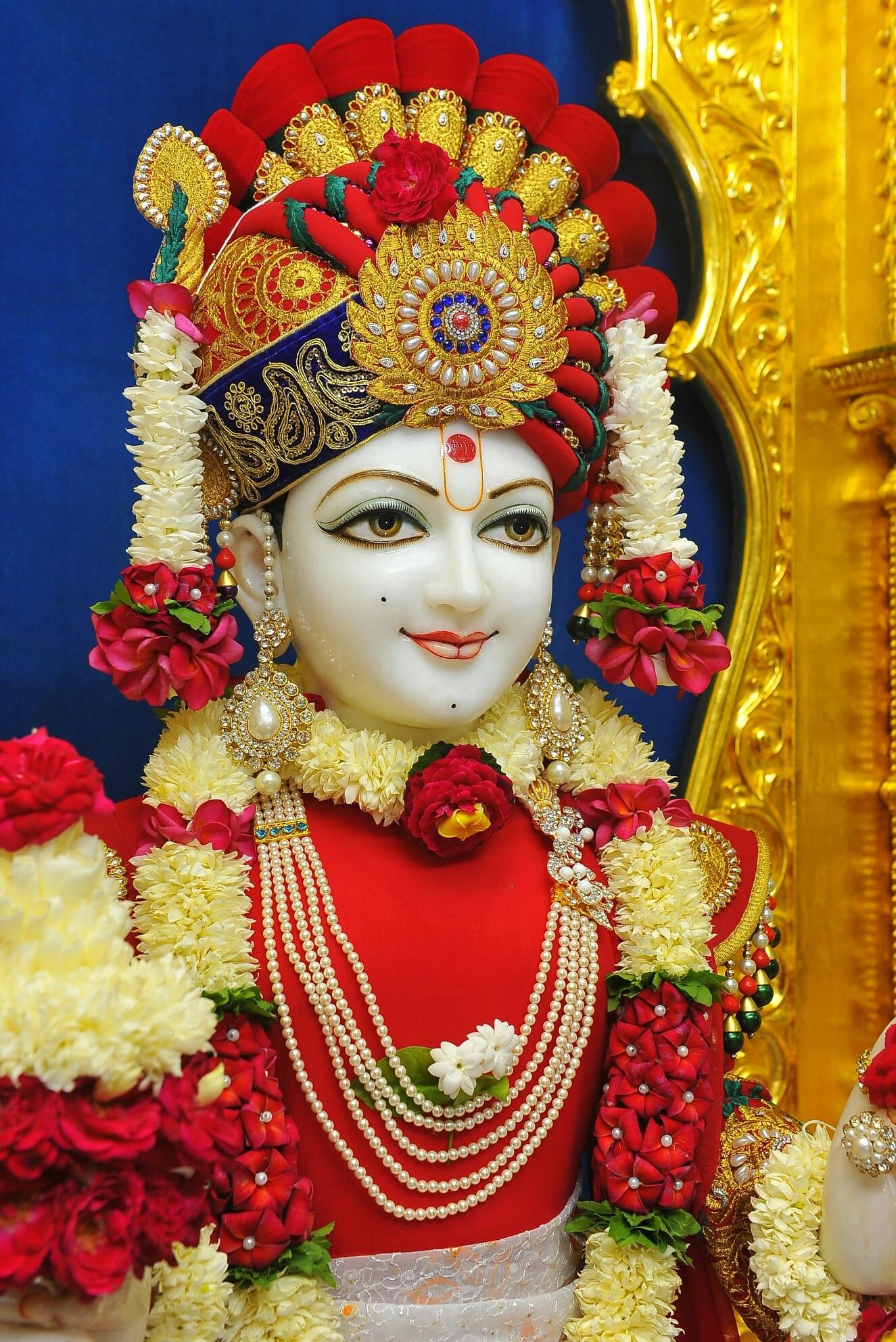 Beautiful Swaminarayan murti with floral adornments