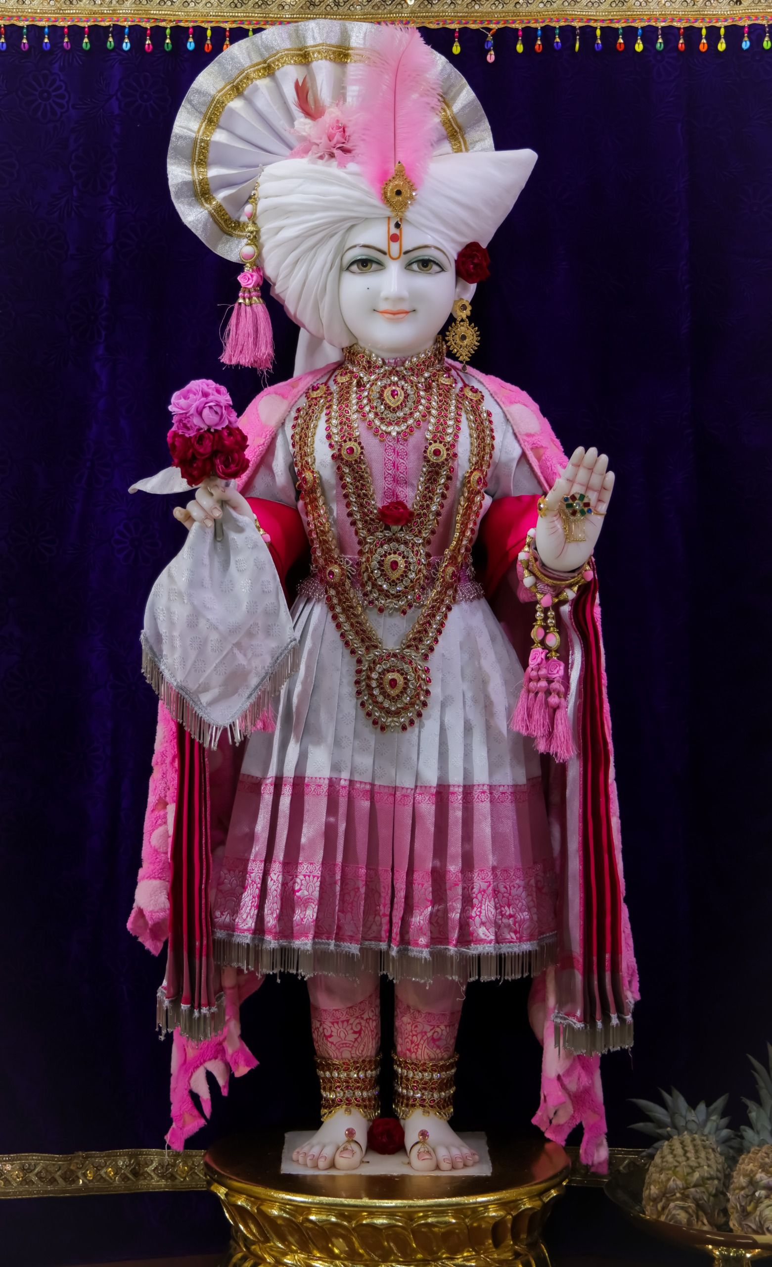 Swaminarayan Bhagwan in pink and gold.