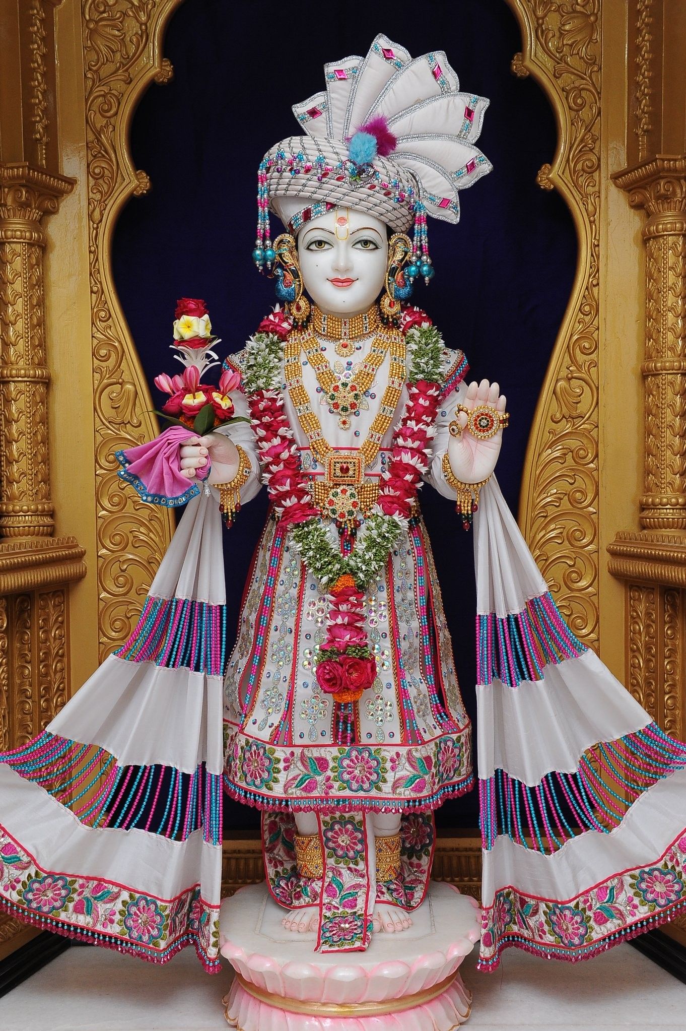 Swaminarayan idol adorned with flowers.