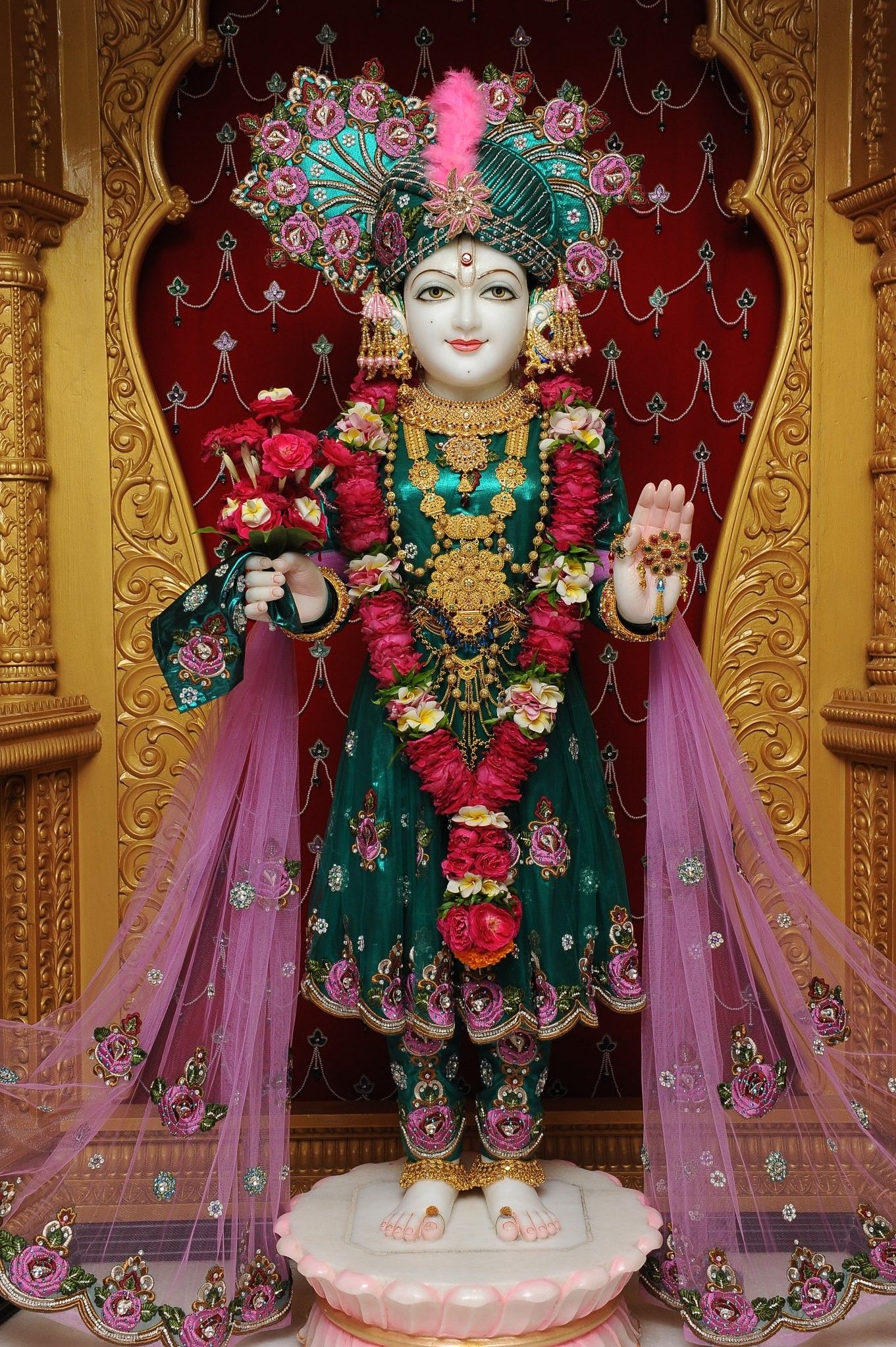 Beautiful Swaminarayan murti adorned with flowers.