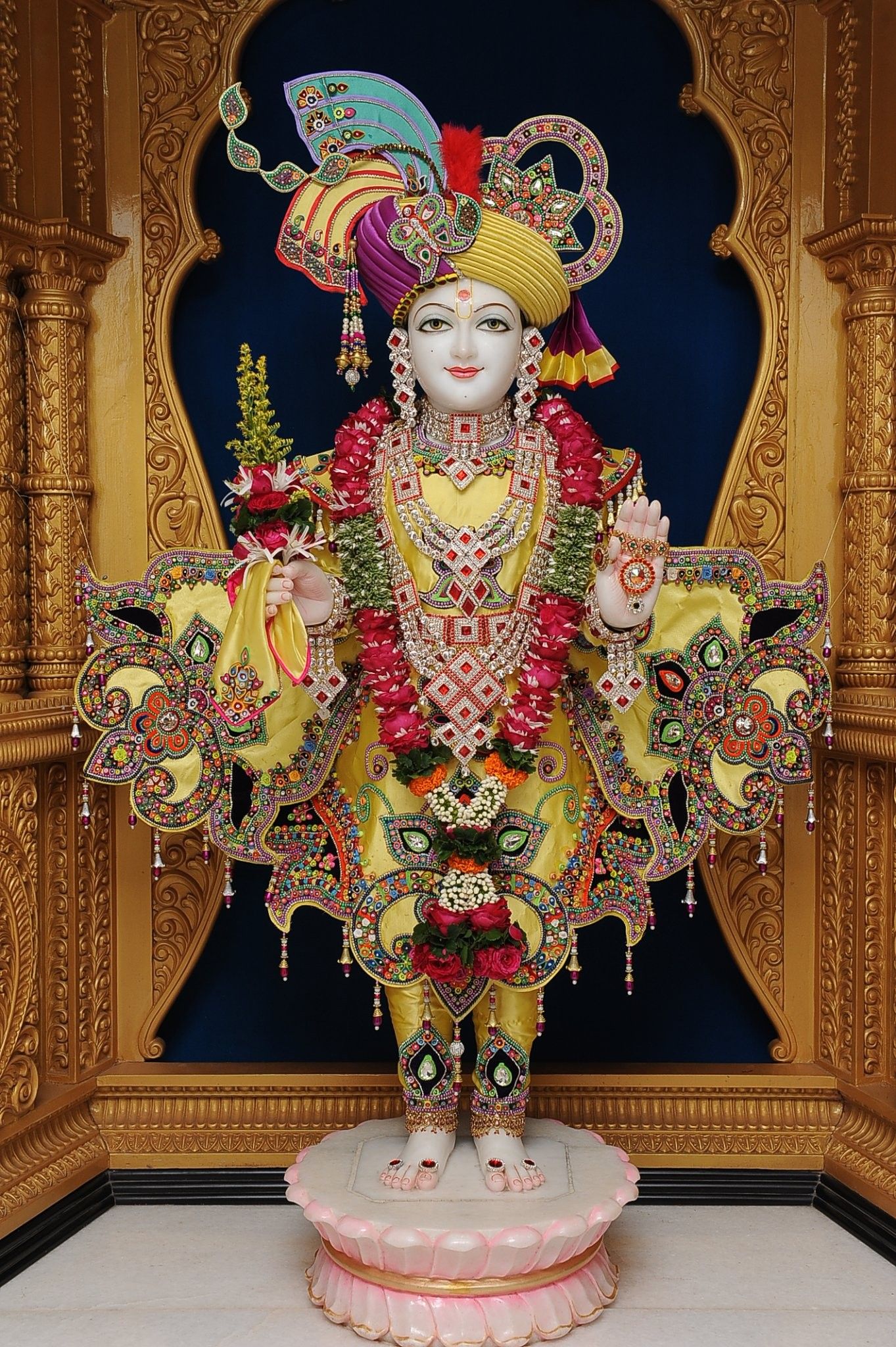 Swaminarayan deity in ornate temple setting.