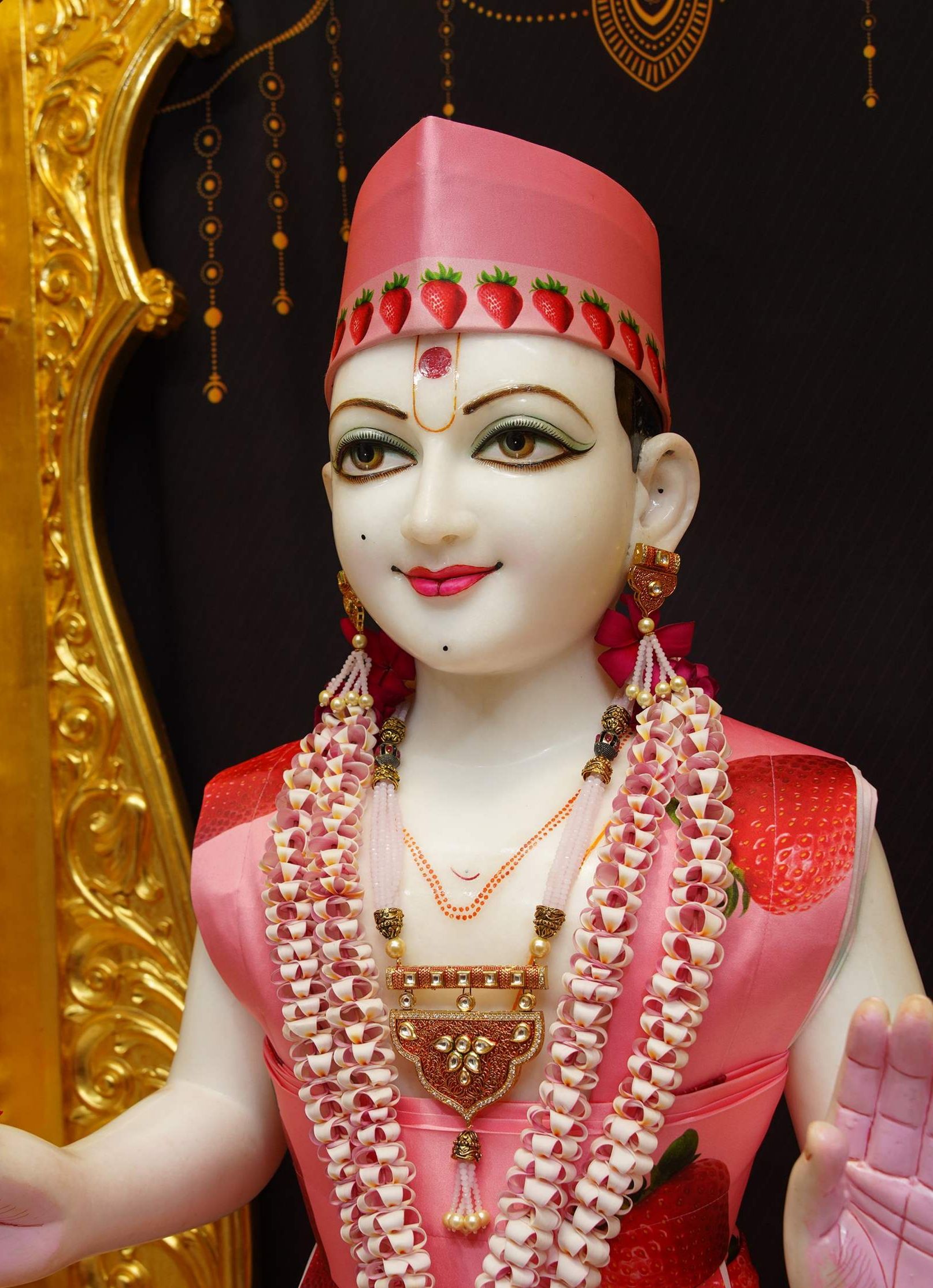 Swaminarayan with strawberry crown statue