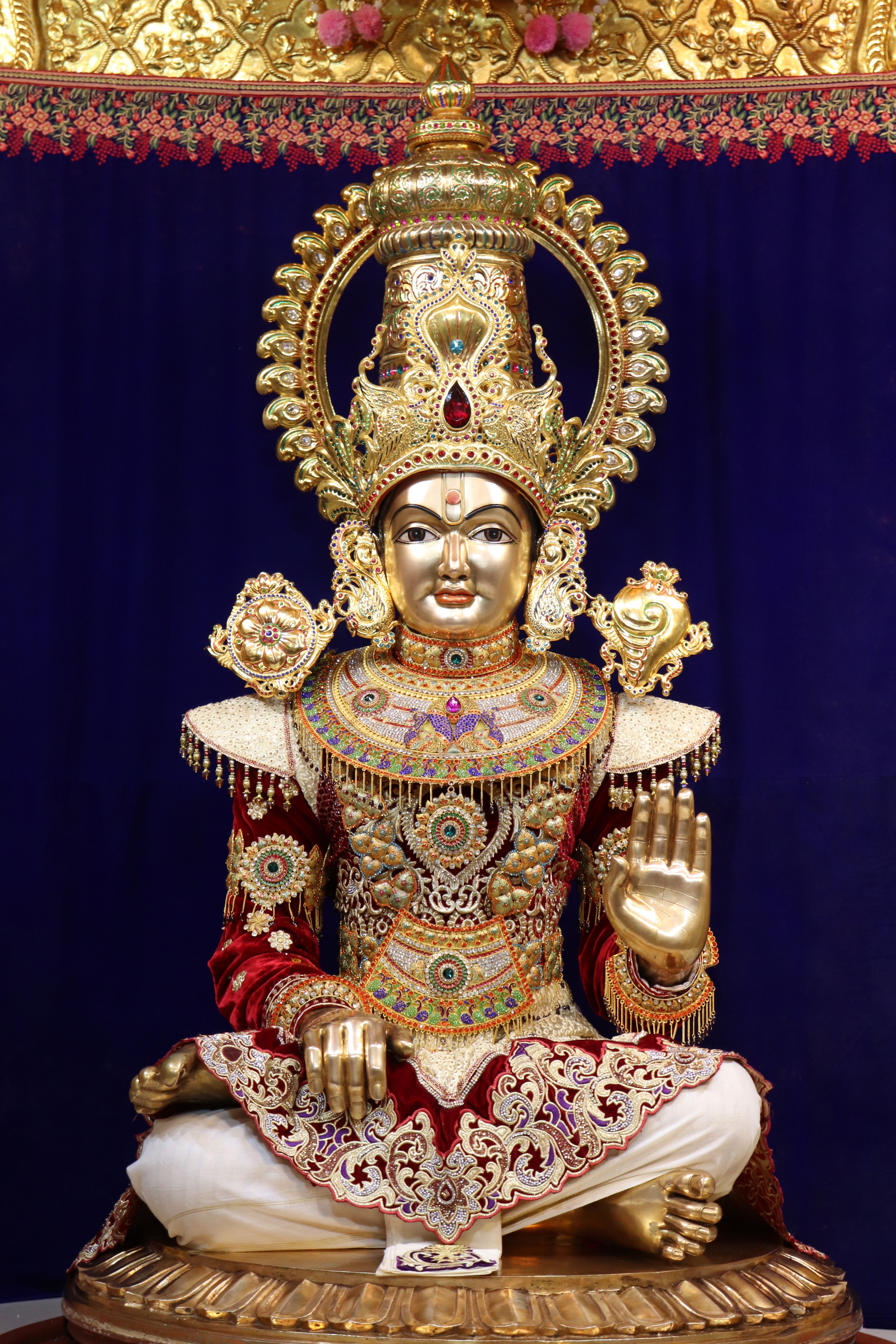 Golden Swaminarayan deity in temple setting