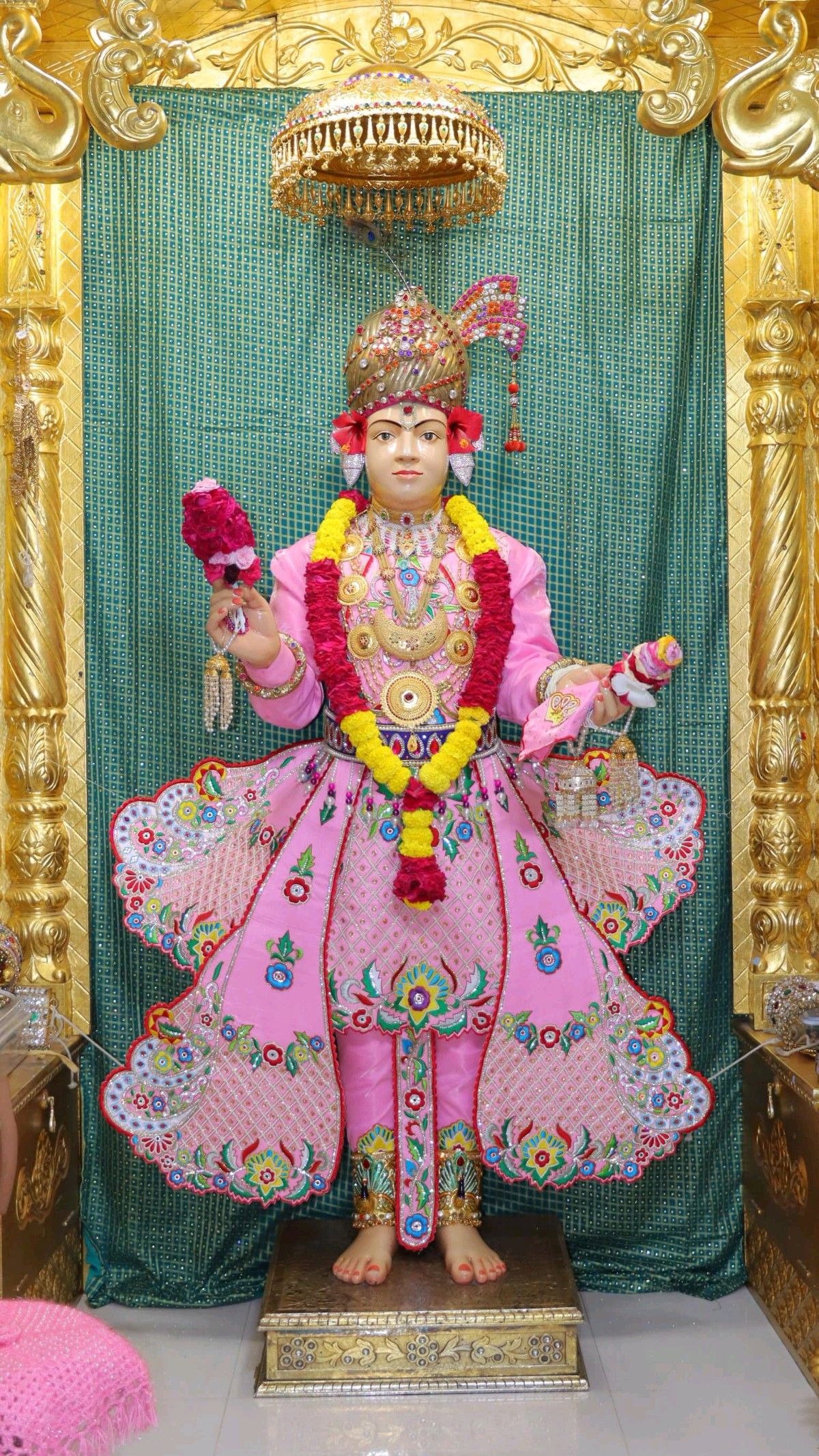 Swaminarayan idol adorned with pink flowers