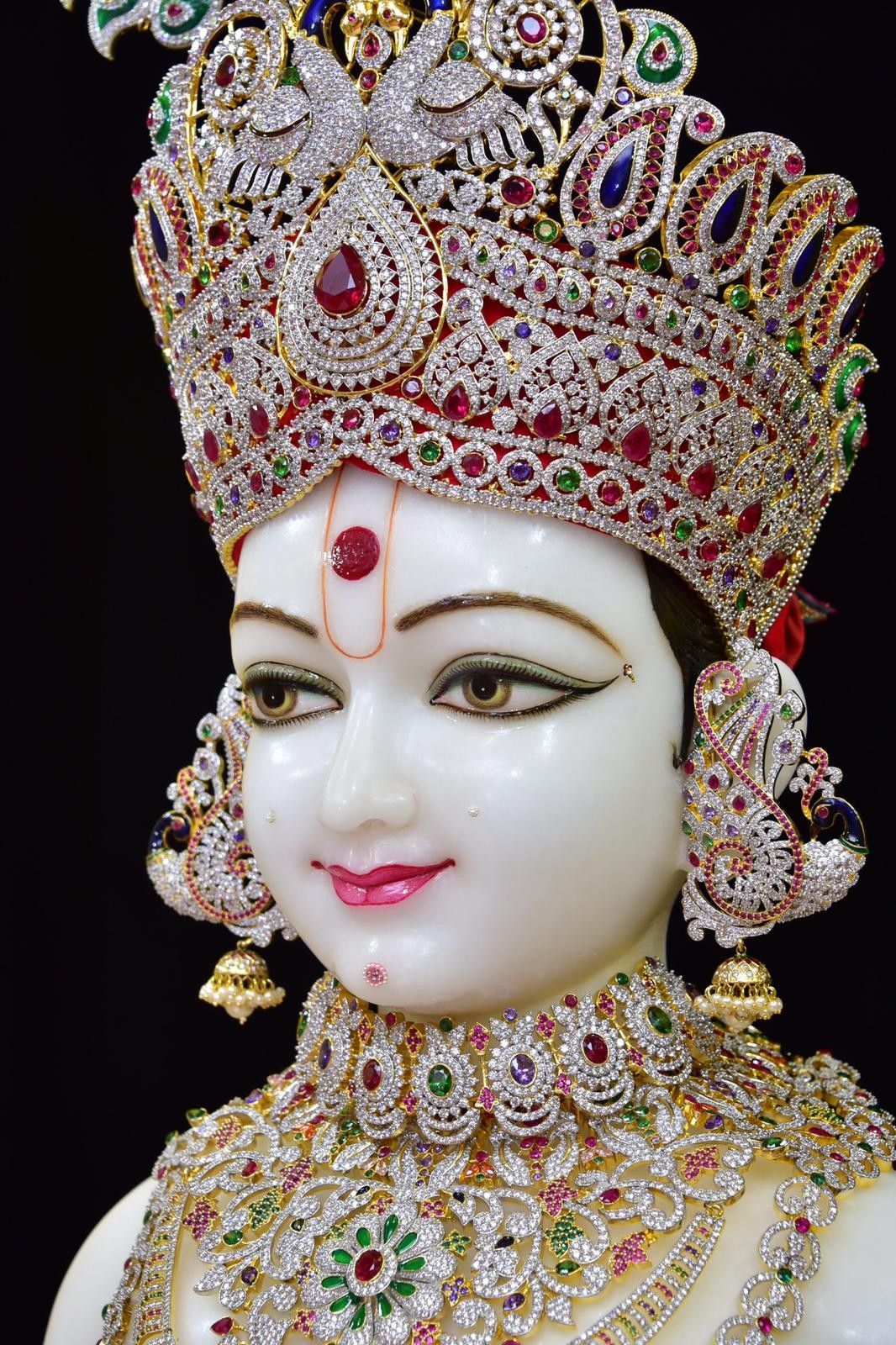 Swaminarayan adorned with jeweled crown.