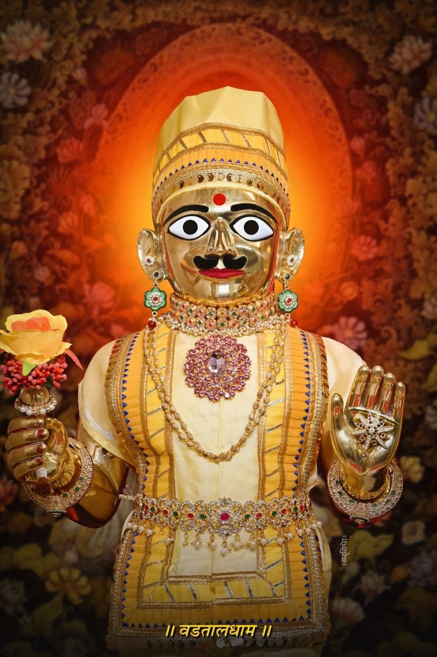 Swaminarayan adorned in gold and flowers.