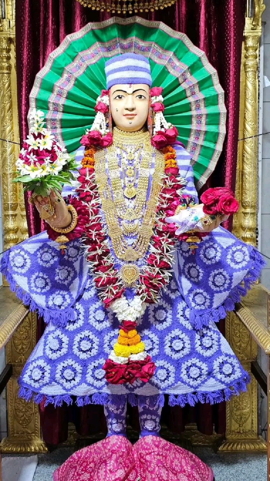 Swaminarayan deity adorned with flowers.