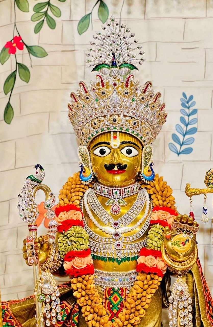 Golden Swaminarayan deity with floral adornments