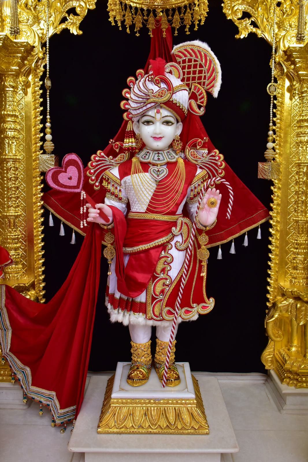 Swaminarayan in red and gold attire