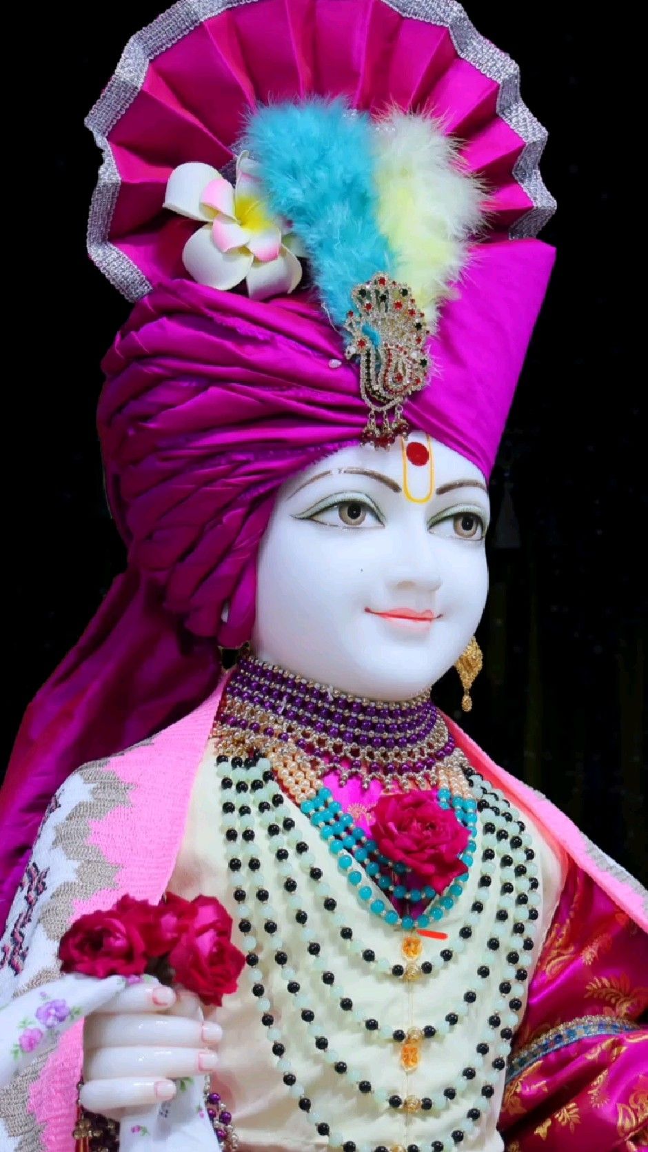 Swaminarayan with floral crown and necklace.