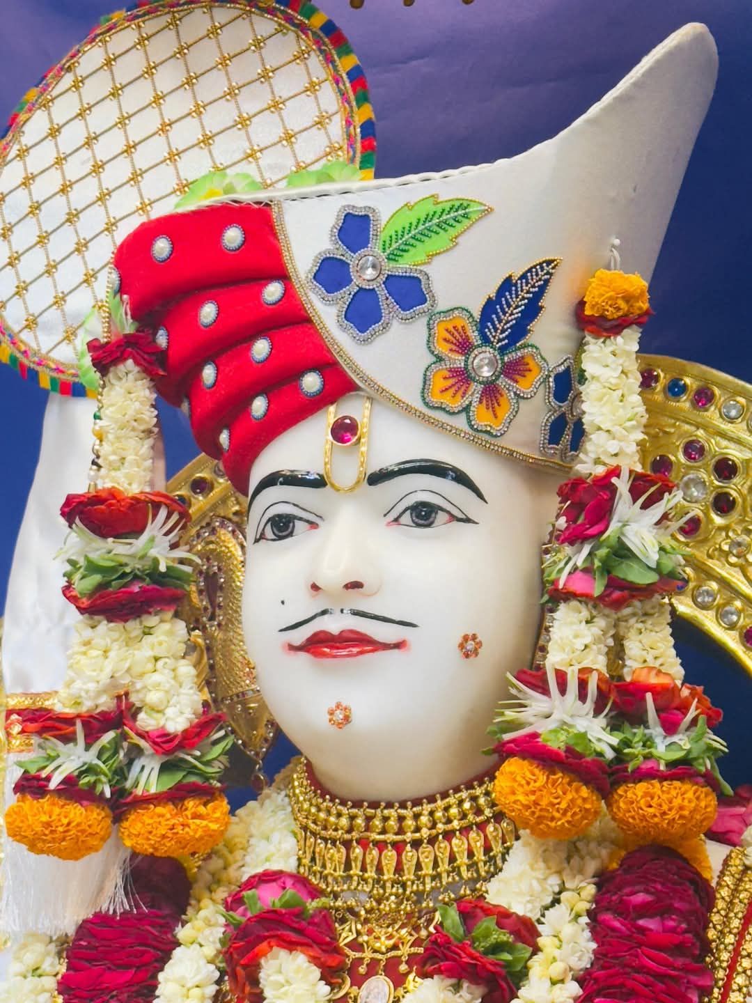 Swaminarayan deity with floral adornments