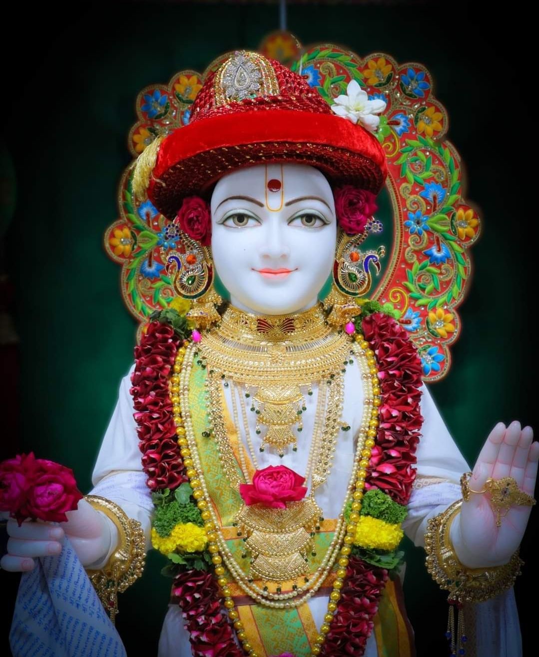 Swaminarayan statue with floral adornments