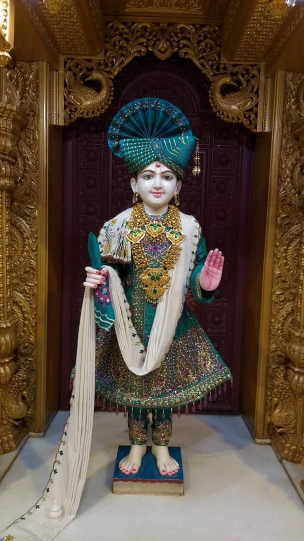 Swaminarayan statue in ornate temple.