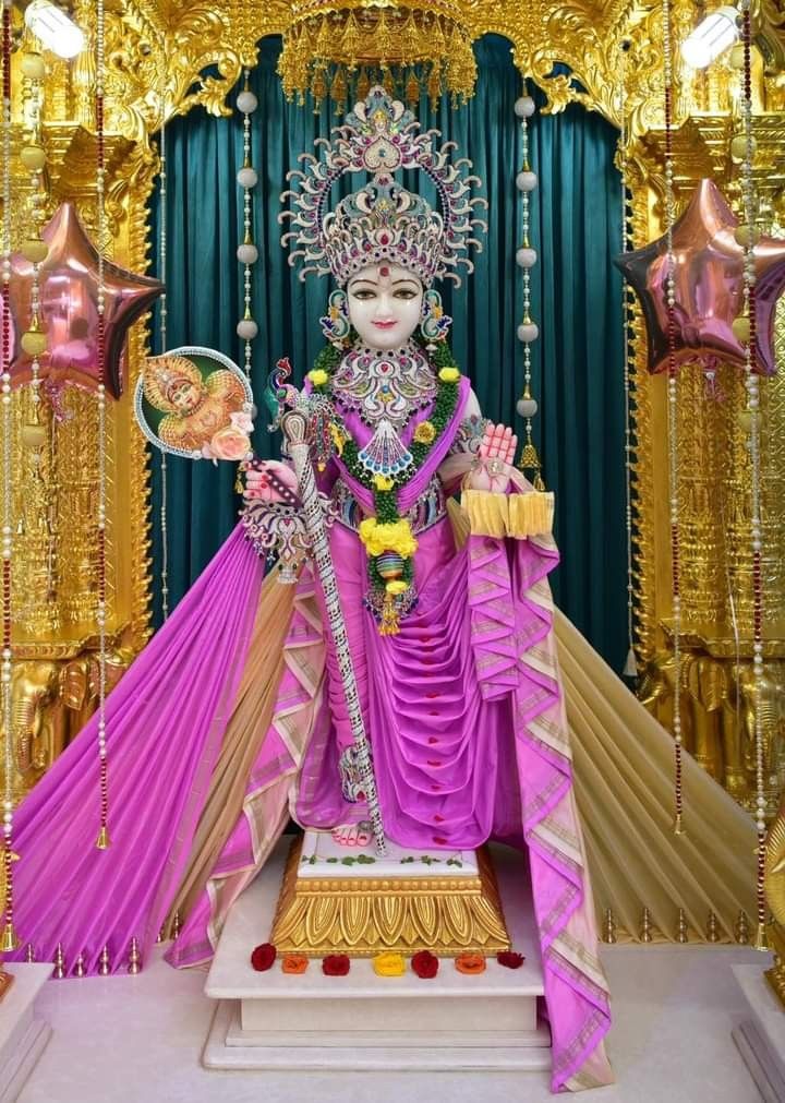 Swaminarayan idol adorned in pink and gold