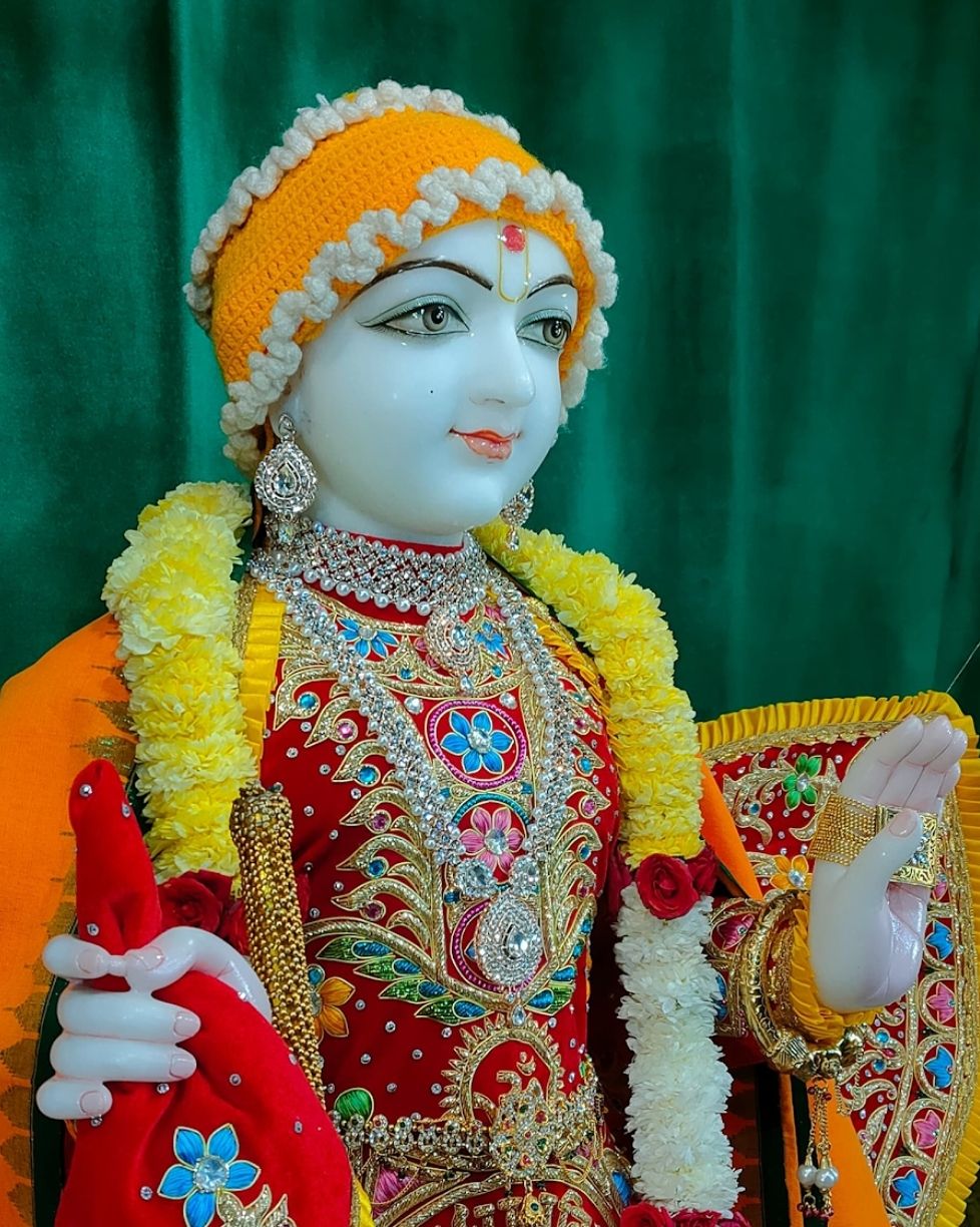 Swaminarayan deity adorned with flowers.