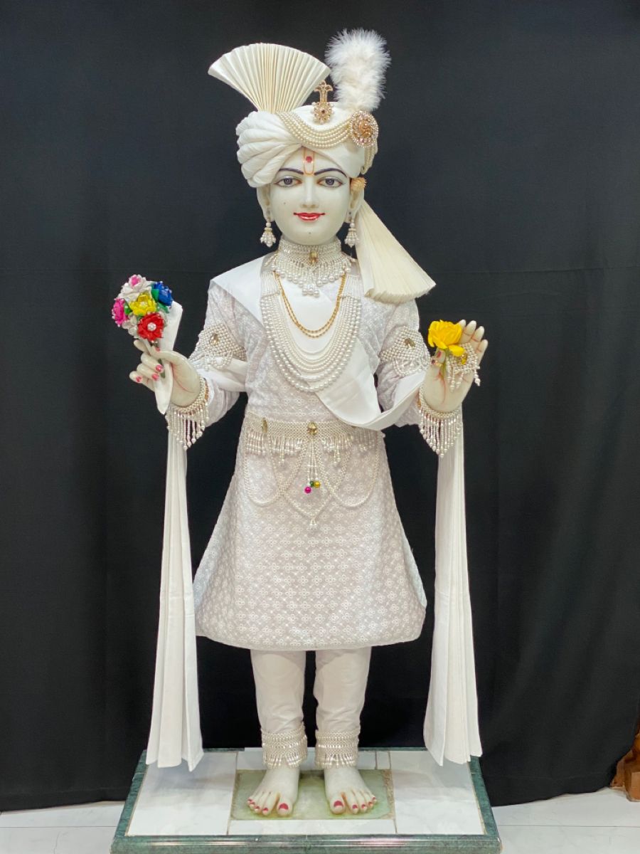 Swaminarayan Bhagwan holding flowers, serene statue