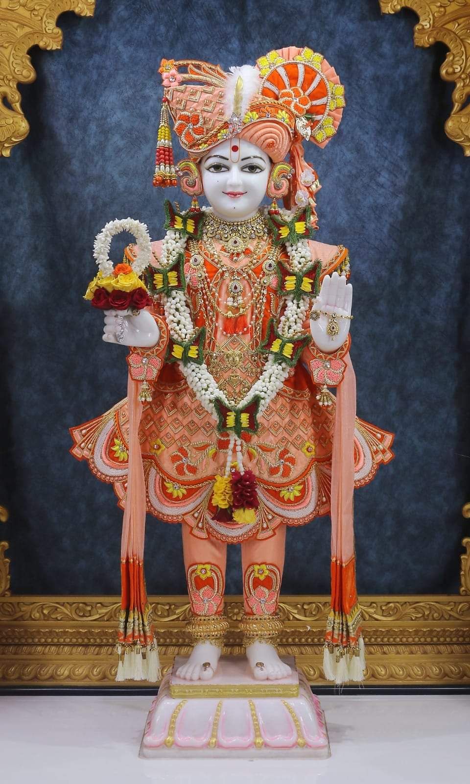 Swaminarayan deity statue with floral garland.