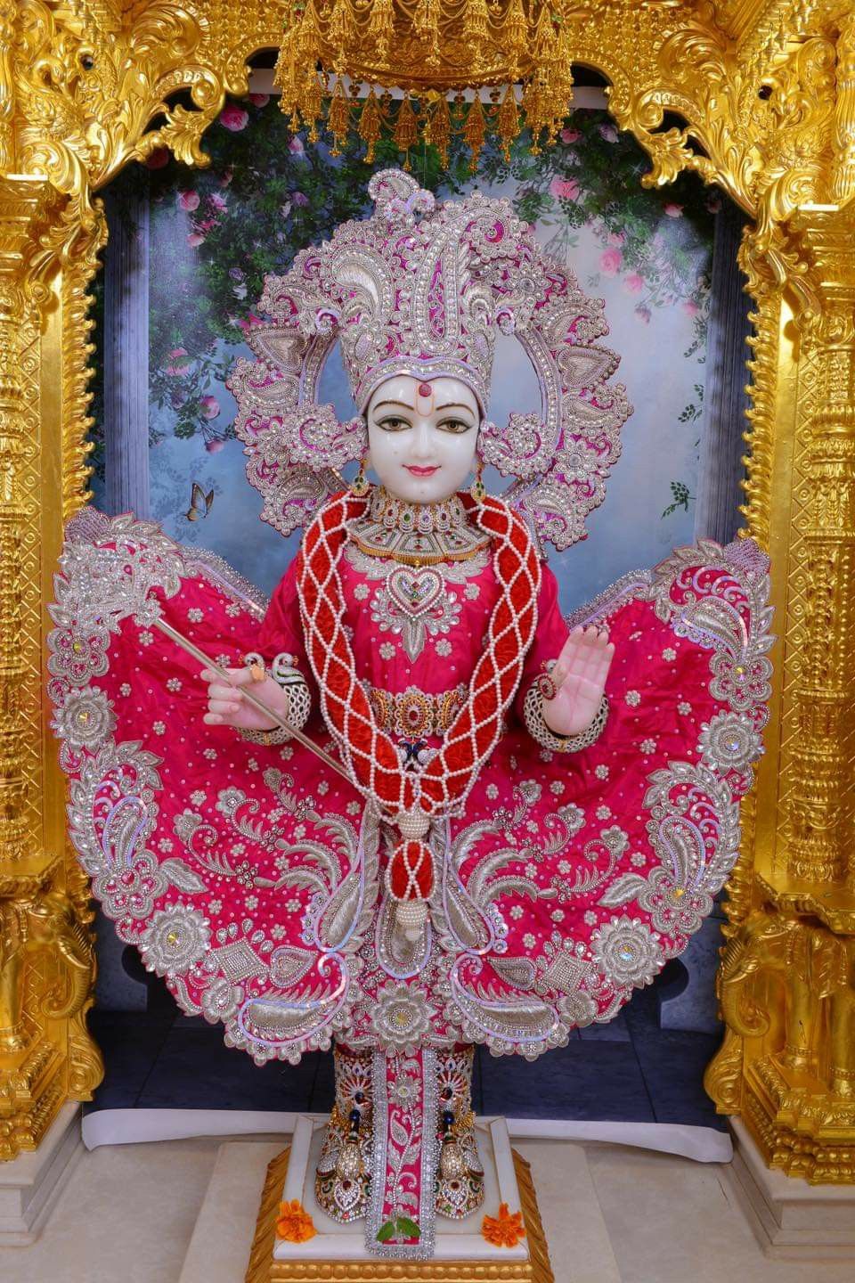 Swaminarayan idol in ornate pink attire
