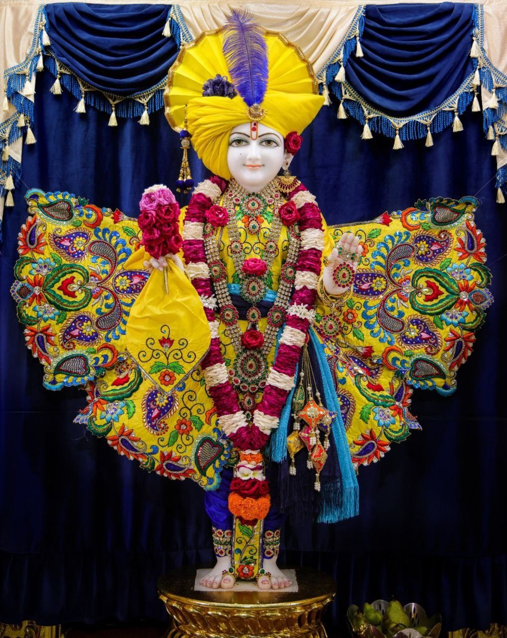 Swaminarayan adorned in vibrant yellow attire