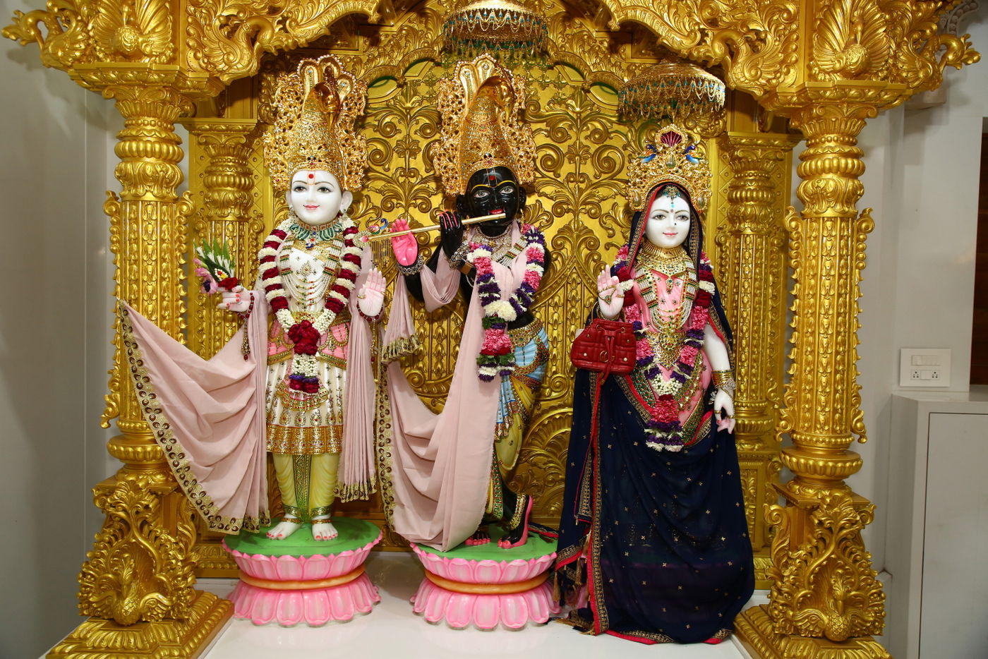 Swaminarayan, Krishna, and Radha statues.