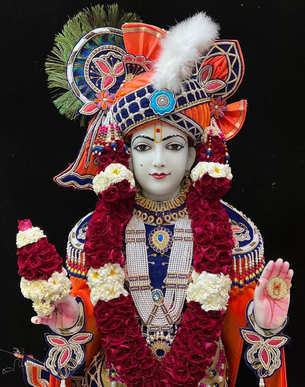 Swaminarayan with floral garland and headwear