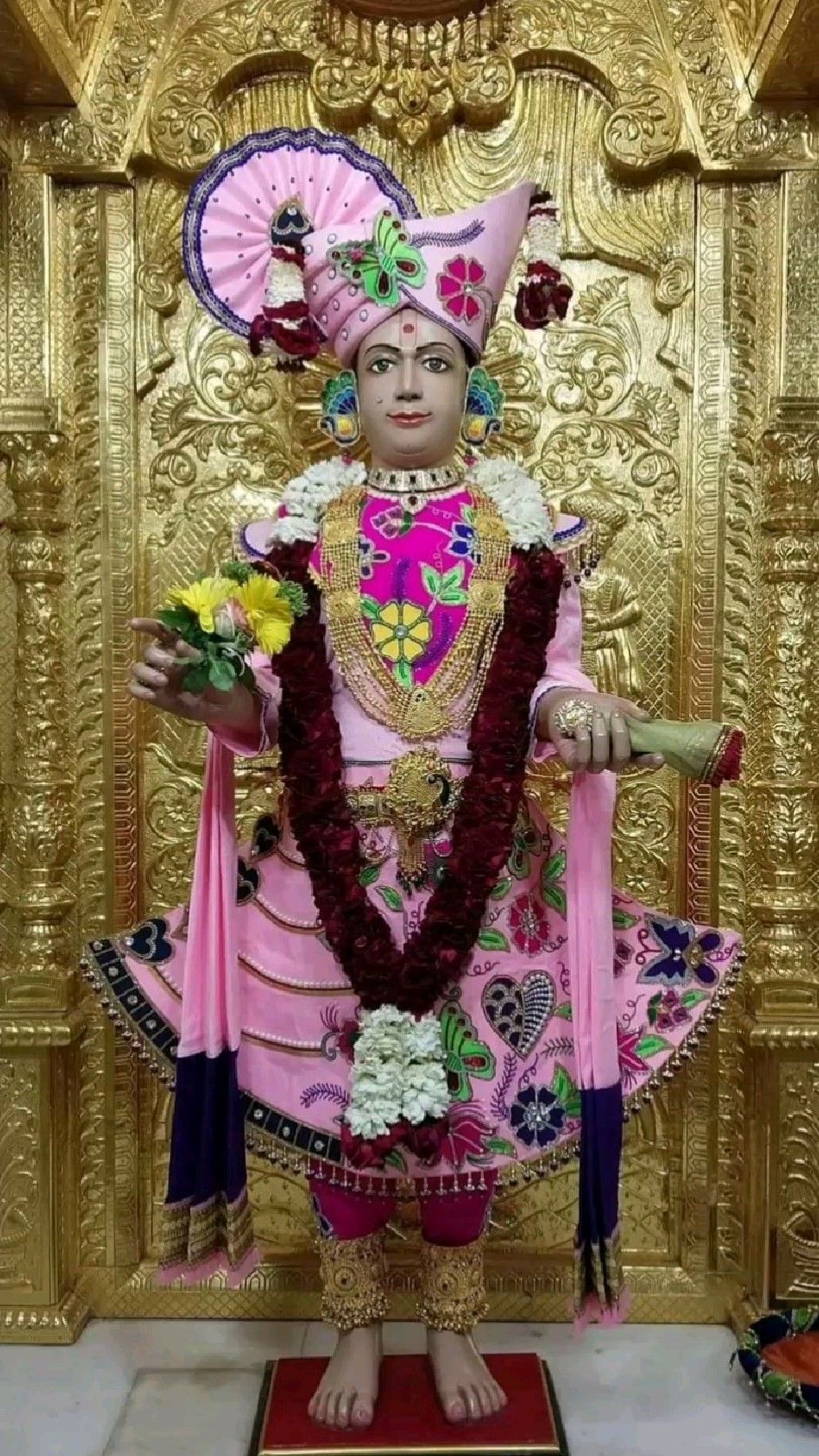 Swaminarayan statue adorned with flowers