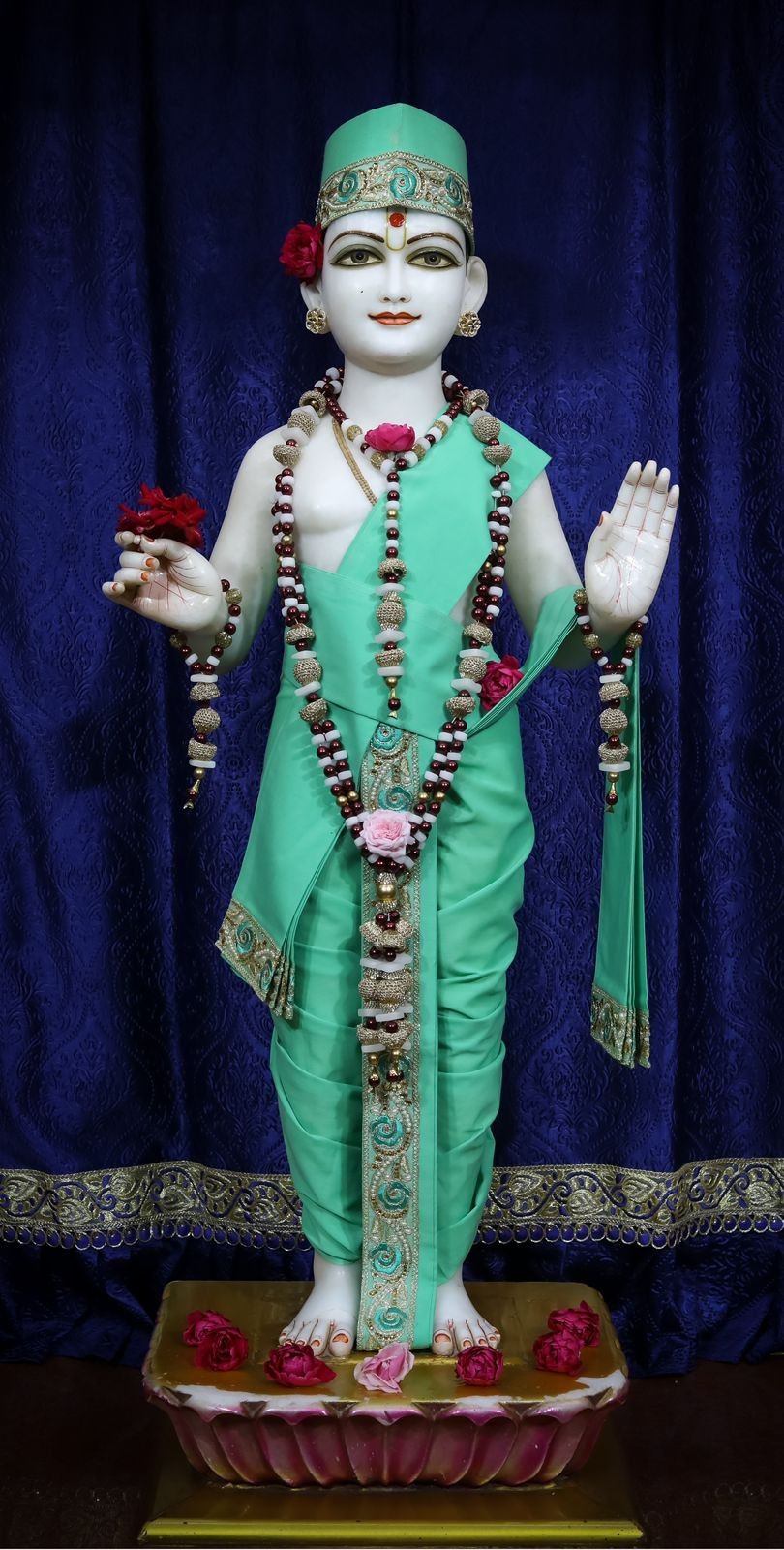 Swaminarayan statue adorned with flowers