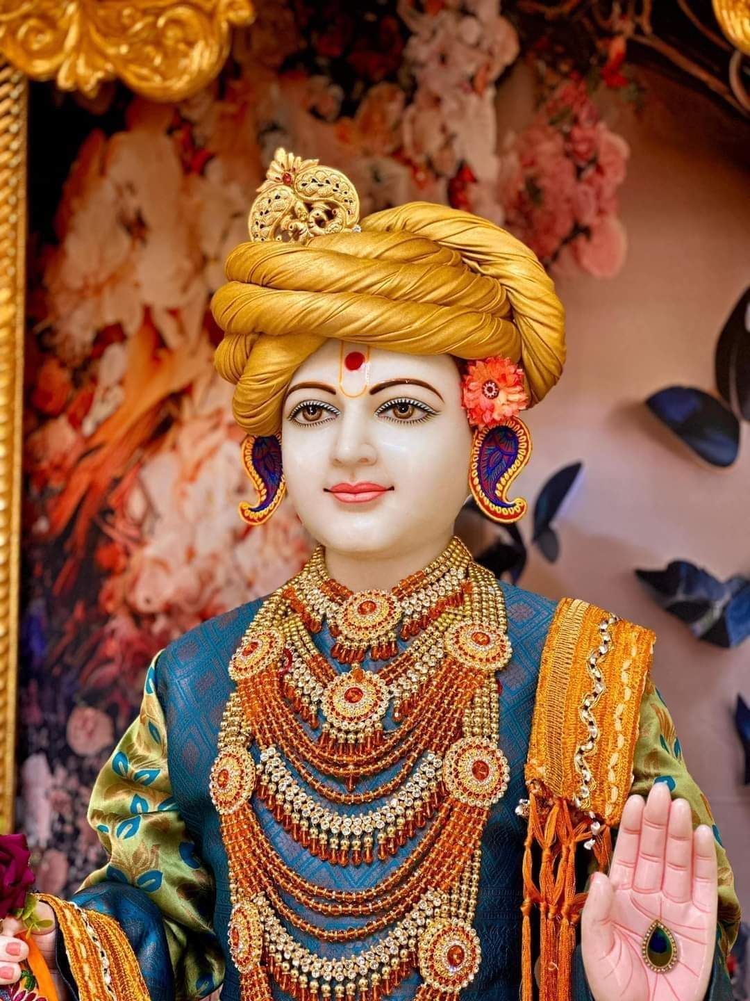 Close-up of Swaminarayan with golden adornments.
