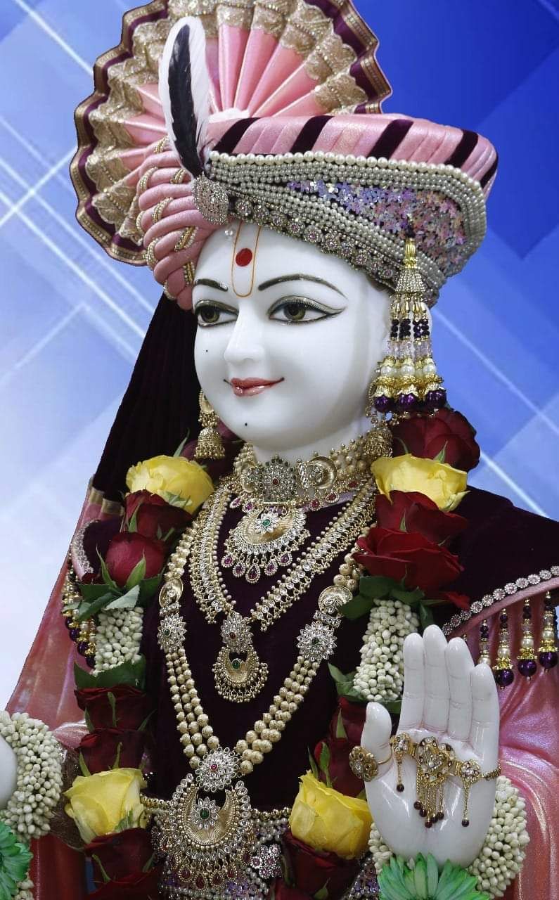 Marble statue of Swaminarayan with floral garland.
